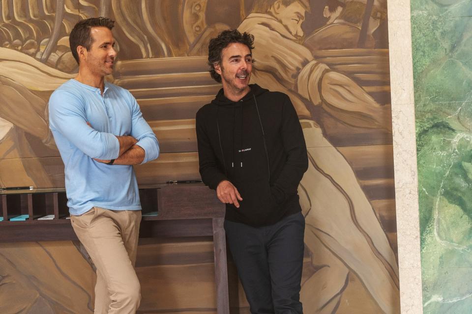 Ryan Reynolds and Shawn Levy smiling and looking at something