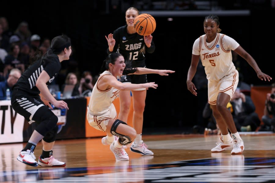 Texas guard Shaylee Gonzales falls after trying to break up a pass by Gonzaga forward Eliza Hollingsworth (12) during the second half of a Sweet 16 college basketball game in the women’s NCAA Tournament, Friday, March 29, 2024, in Portland, Ore. (AP Photo/Howard Lao)
