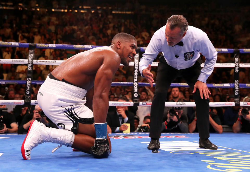 Anthony Joshua (left) spits his gum shield onto the floor as referee Mike Griffin starts a count during the match against Andy Ruiz Je at Madison Square Garden, New York.