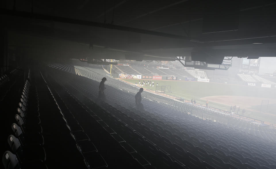 Smoke from a concession stand fire filters out to the seats at AT&T Park before a baseball game between the Houston Astros and the San Francisco Giants, Monday, Aug. 6, 2018, in San Francisco. The fire was put out by the time firemen arrived and there was no expected delay of the game. (AP Photo/Eric Risberg)