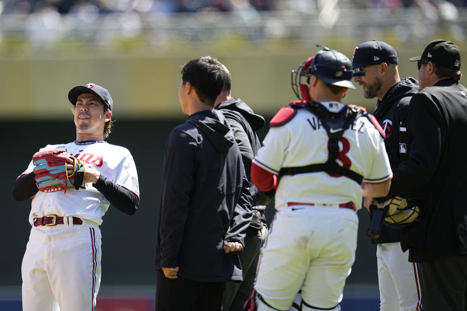 Minnesota Twins starting pitcher Kenta Maeda, left, is attended to by team staff after a fall during the second inning of a baseball game against the New York Yankees, Wednesday, April 26, 2023, in Minneapolis. (AP Photo/Abbie Parr)