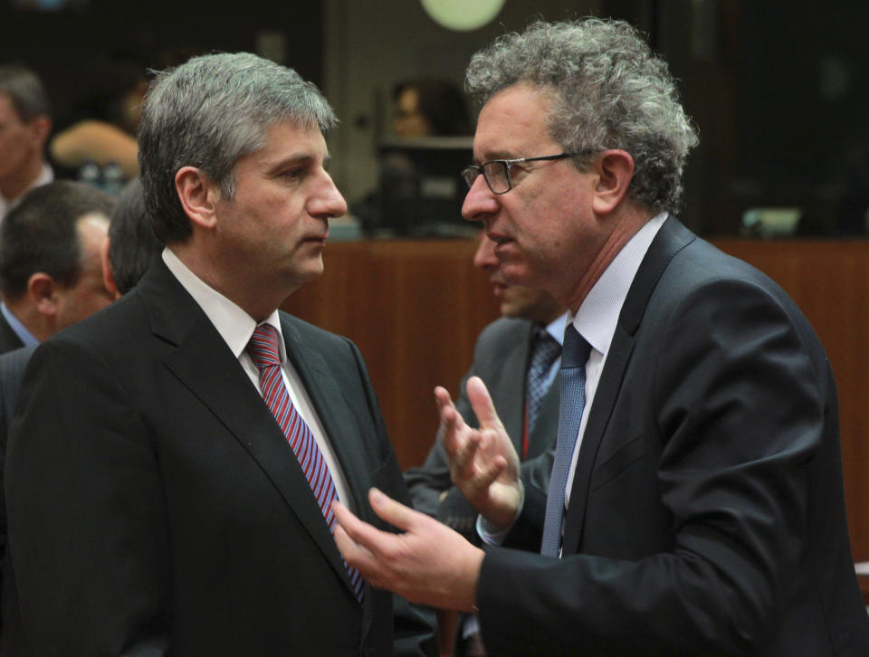 Austrian Finance Minister Michael Spindelegger, left, talks with his Luxembourg's counterpart Pierre Gramegna at the start of an EU finance ministers meeting at the European Council building in Brussels, Tuesday, March 11, 2014. The Council prepares the presidency's mandate to finalize negotiations with the European Parliament on the proposal for a single resolution mechanism for banks. (AP Photo/Yves Logghe)