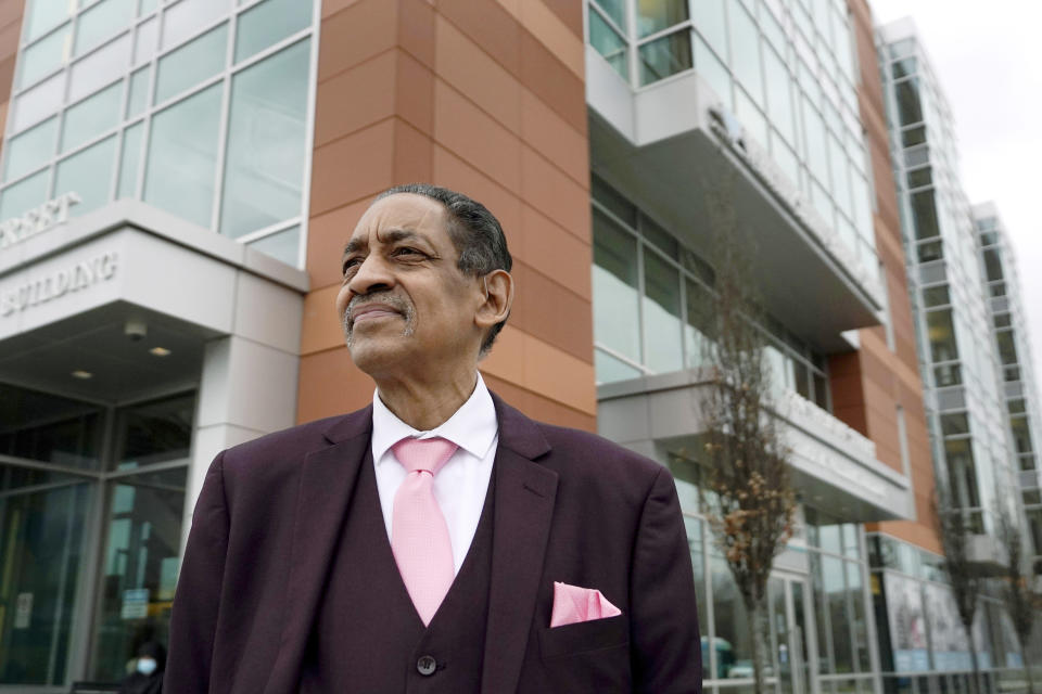 Nestor Castro, 67, of Cambridge, Mass., poses for a photo at Whittier Street Health Center, Thursday, March 31, 2022, in Boston, where he volunteers. Just before Christmas in 2021, Castro got a permanent subsidized apartment through Hearth Inc., a Boston nonprofit dedicated to ending homelessness among older adults. (AP Photo/Steven Senne)