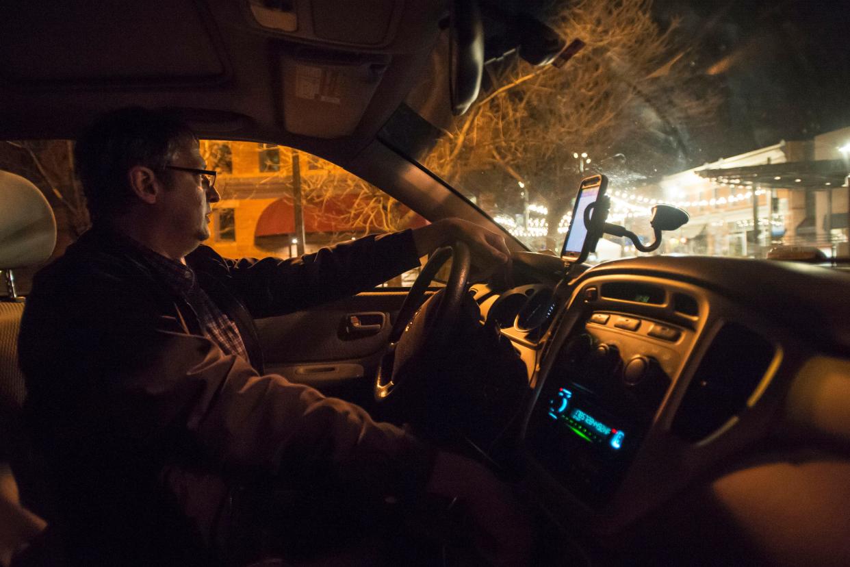 Uber and Lyft driver Scott Saathoff waits for passengers to make their way to his vehicle early on a Sunday morning in Old Town Fort Collins in 2018.