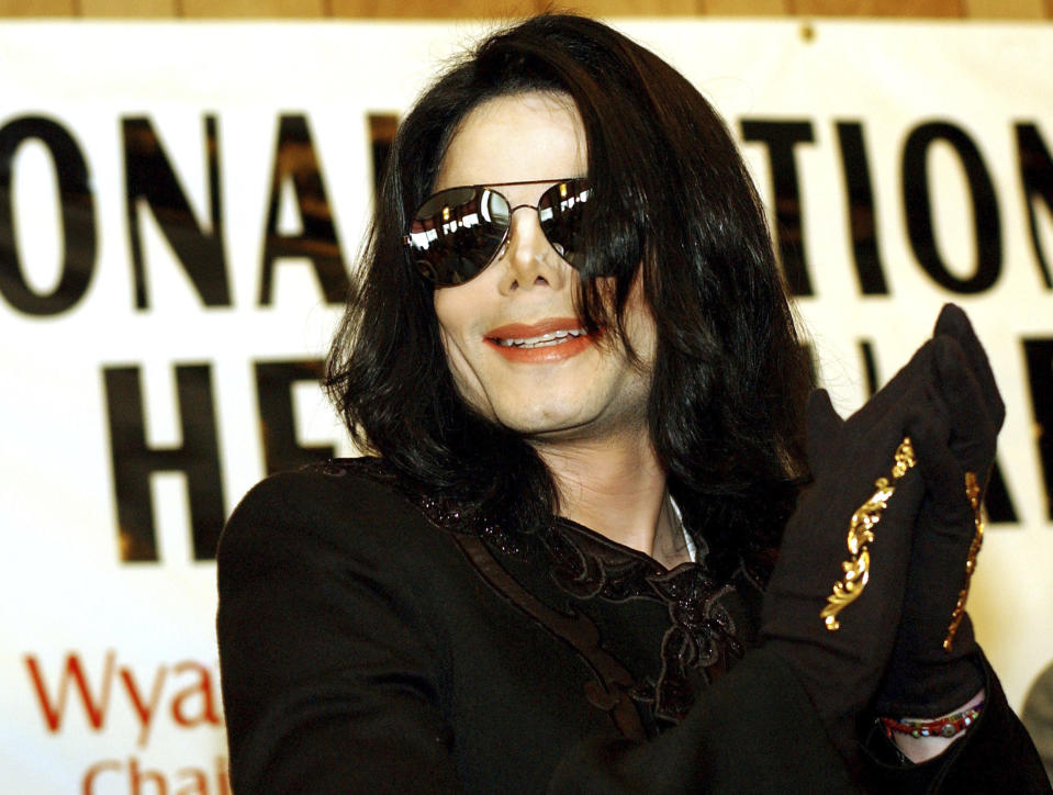 FILE - Michael Jackson applauds as he looks out into the audience July 6, 2002, at Rev. Al Sharpton's National Action Network headquarters in Harlem, New York. With a series of court victories and shows beginning or returning after a long pandemic pause, Jackson's estate, and his legacy are on the upswing again. Estate co-executor John Branca said in an interview with The Associated Press that his optimism never flagged as crises hit. (AP Photo/Stephen Chernin, File)