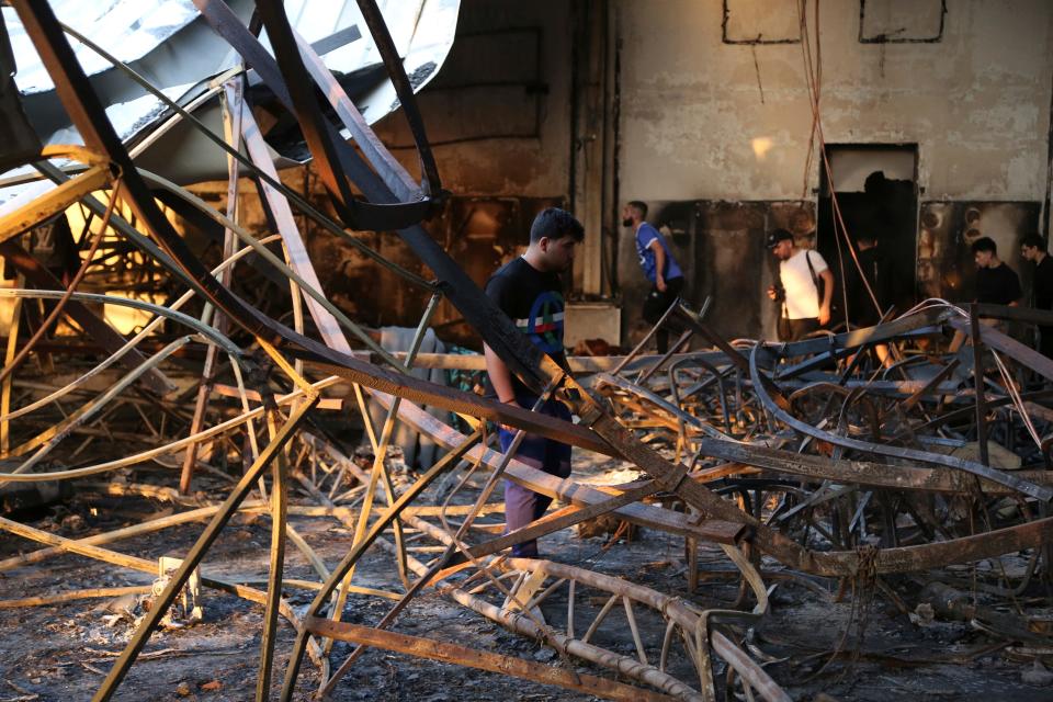 People gather at the site of a fatal fire, in the district of Hamdaniya, Nineveh province, Iraq, Wednesday, Sept. 27, 2023. A fire that raced through a hall hosting a Christian wedding in northern Iraq killed multiple people, authorities said Wednesday.