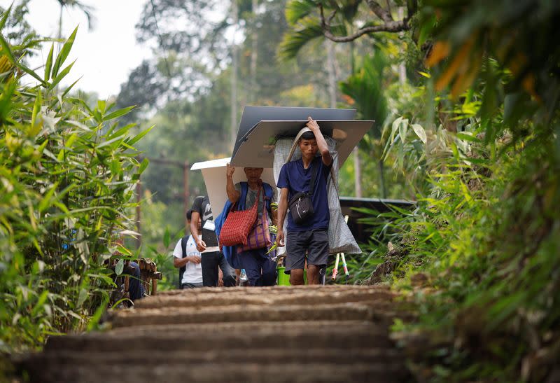 Polling officers and porters carry VVPAT and EVM to a remote village in Shillong