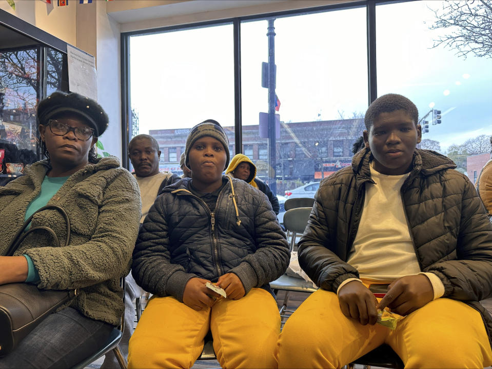 The Alexis family waits in the Immigrant Family Services Institute in Mattapan, Massachusetts on Wednesday, Nov. 15, 2023. The family arrived in Boston a week ago and are struggling to find housing after the state capped the number of family shelter spots and created a wait list. (AP Photo/Michael Casey)