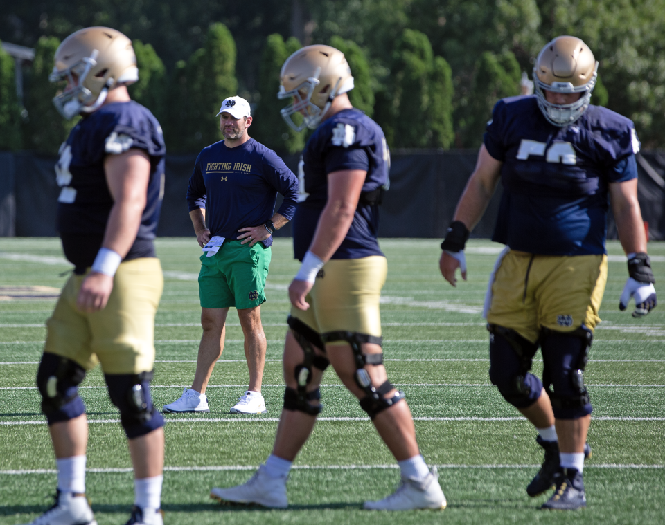 Notre Dame offensive coordinator Gerad Parker, second from left, watches offensive linemen go through a drill during practice Thursday, July 27, 2023, in South Bend.