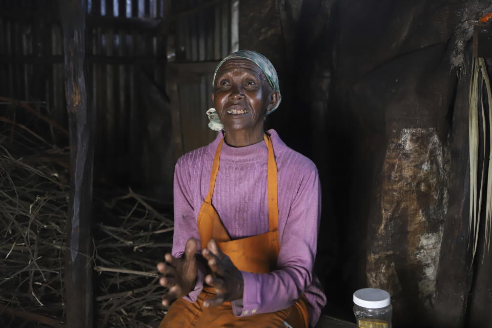 Jane Muthoni, 65, speaks at her home during an interview with The Associated Press in Kiambu, Kenya, Tuesday, May 21, 2024. Piles of firewood surrounded Jane Muthoni in her kitchen made of iron sheets. The roof, walls and wooden pillars were covered in soot. As she blew on the flame for tea, the 65-year-old was engulfed in smoke. She was unaware of the lasting toll on her health. (AP Photo/Andrew Kasuku)