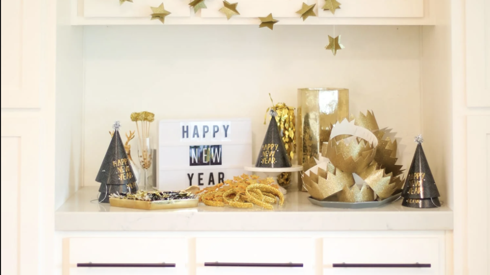 a white cupboard with a collection of party hats and crowns displayed on it