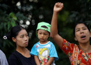 A woman caryrying her son watches as a local protests against former U.N. Secretary-General Kofi Annan, who is visiting in his capacity as the Myanmar government-appointed Chairman of the Advisory Commission on Rakhine State, near Sittwe airport, Rakhine state, Myanmar December 2, 2016. REUTERS/Soe Zeya Tun