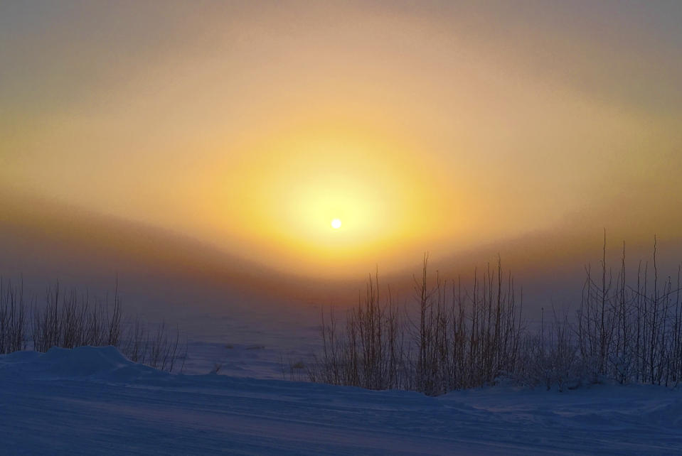 The sun rises through ice fog on the Yukon River Wednesday, Jan. 18, 2017, in Tanana, Alaska. The temperature Wednesday at the Tanana airport reached 54 below zero, the coldest recorded in the state, and was 5 degrees colder at -59 along the river. (Cynthia Erickson via AP)