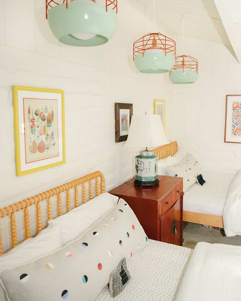 serene white kids room with muted color accents and light wood framed beds