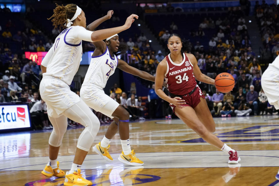 Arkansas guard Chrissy Carr (34) drives to the basket past LSU guard Flau'jae Johnson (4) and forward LaDazhia Williams (0)in the first half an NCAA college basketball game in Baton Rouge, La., Thursday, Jan. 19, 2023. (AP Photo/Gerald Herbert)