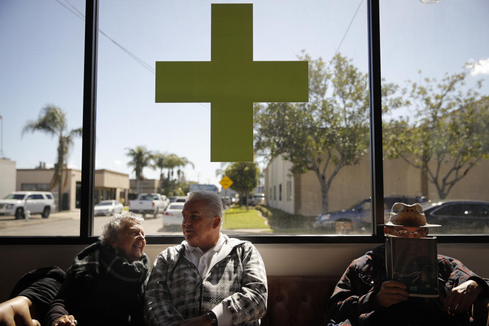 FILE - Kay Nelson, left, and Bryan Grode, retried seniors from Laguna Woods Village, chat in the lobby of Bud and Bloom cannabis dispensary while waiting for a free shuttle to arrive in Santa Ana, Calif., Feb. 19, 2019. A federal proposal to reclassify marijuana as a less dangerous drug has raised the hopes of some pot backers that more states will embrace cannabis. (AP Photo/Jae C. Hong, File)