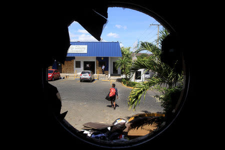 A man is seen through the window of a supermarket looted by demonstrators in Managua, April 23, 2018. REUTERS/Jorge Cabrera