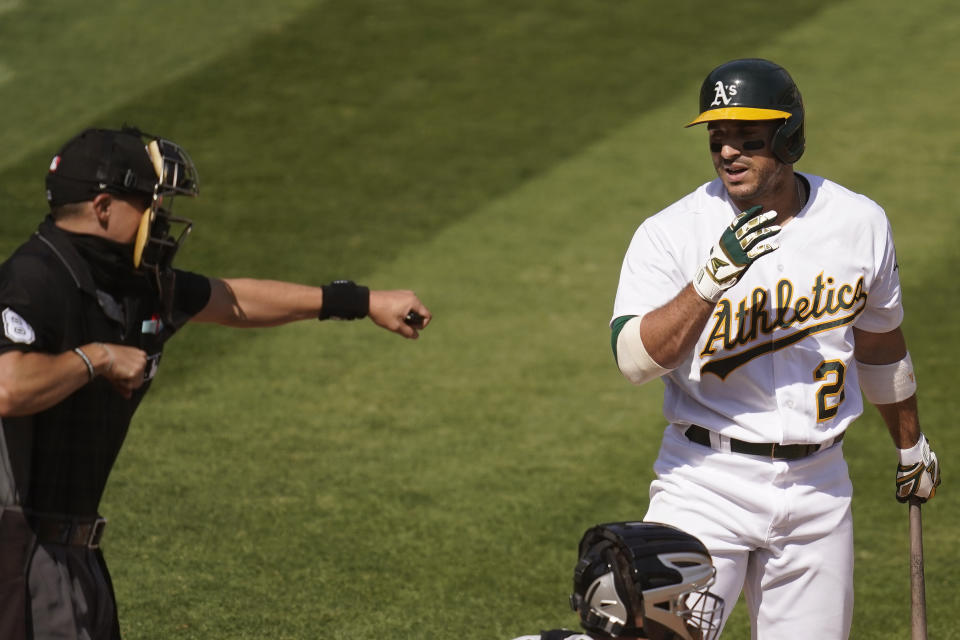 Home plate umpire Adam Hamari, left, gestures after Oakland Athletics' Ramon Laureano, right, struck out against Chicago White Sox pitcher Lucas Giolito during the sixth inning of Game 1 of an American League wild-card baseball series Tuesday, Sept. 29, 2020, in Oakland, Calif. (AP Photo/Eric Risberg)