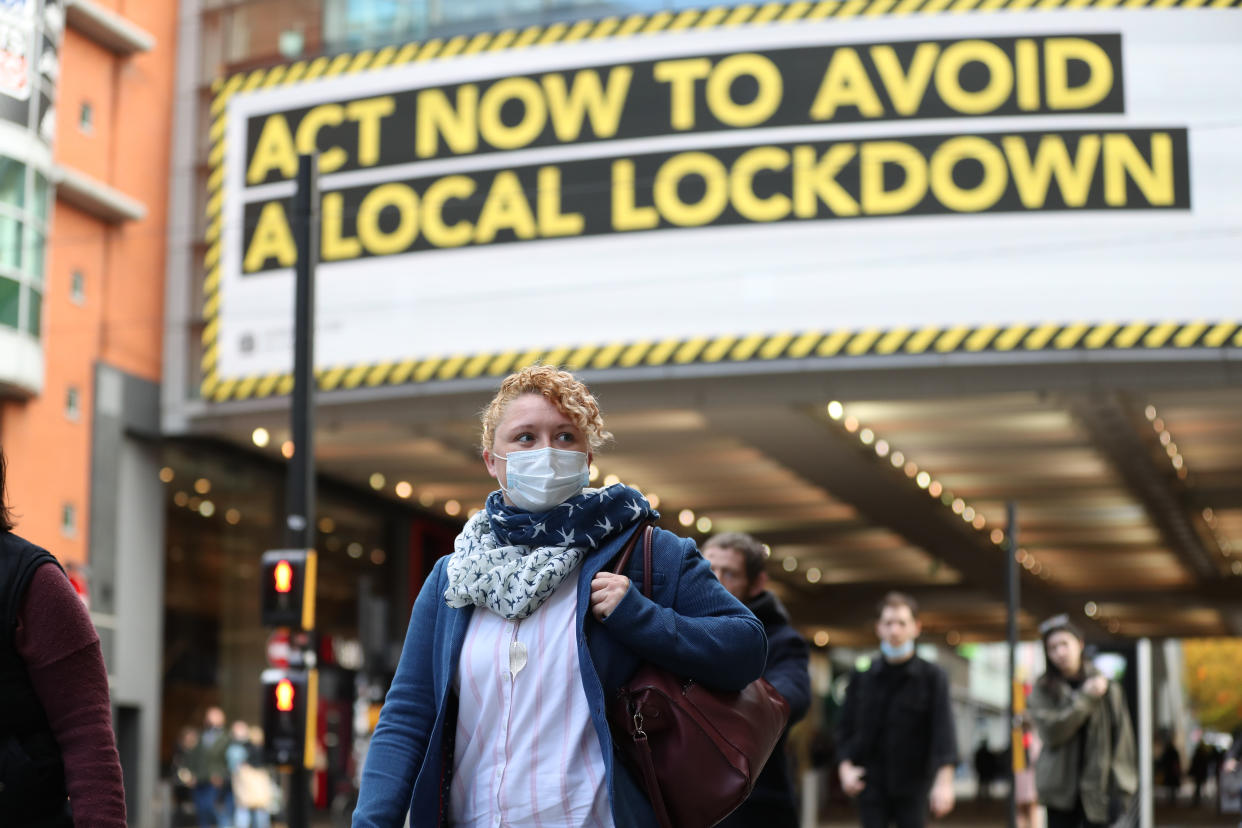 A woman wearing a face mask walks through Manchester. Greater Manchester will be placed under stricter coronavirus controls after last-ditch talks with the Prime Minister aimed at securing additional financial support concluded without an agreement. (Photo by Martin Rickett/PA Images via Getty Images)