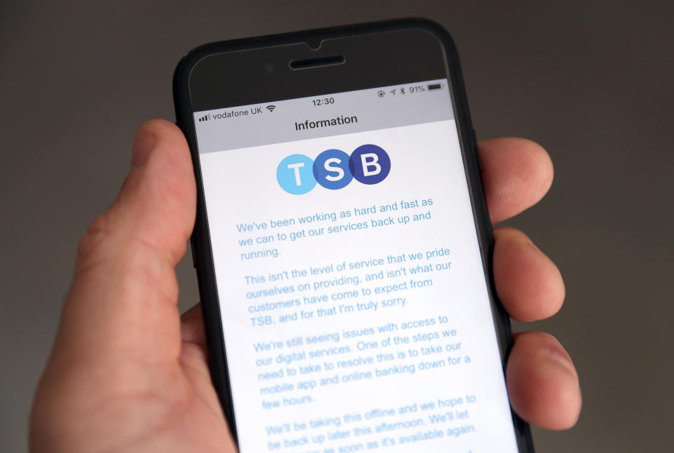 A customer using the TSB Online banking app on an iPhone reads a message from TSB CEO Paul Pester apologising for IT issues which left online customers unable to access their money and some able to see other people's accounts. (Photo by Andrew Matthews/PA Images via Getty Images)