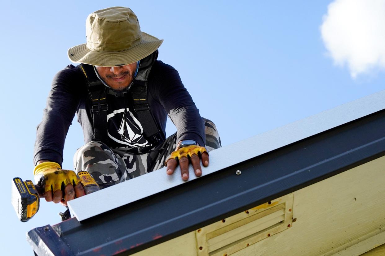 A roofer replaces an old roofing system at a home in Indiantown in Martin County in this photo shot last year.