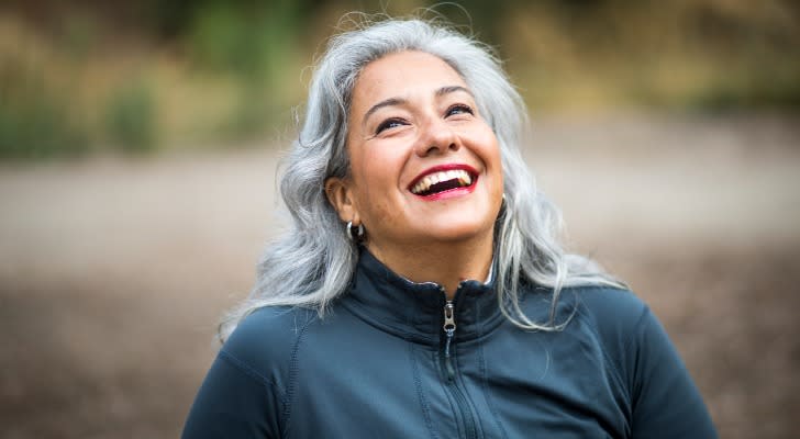 A retiree smiles while taking a walk. 