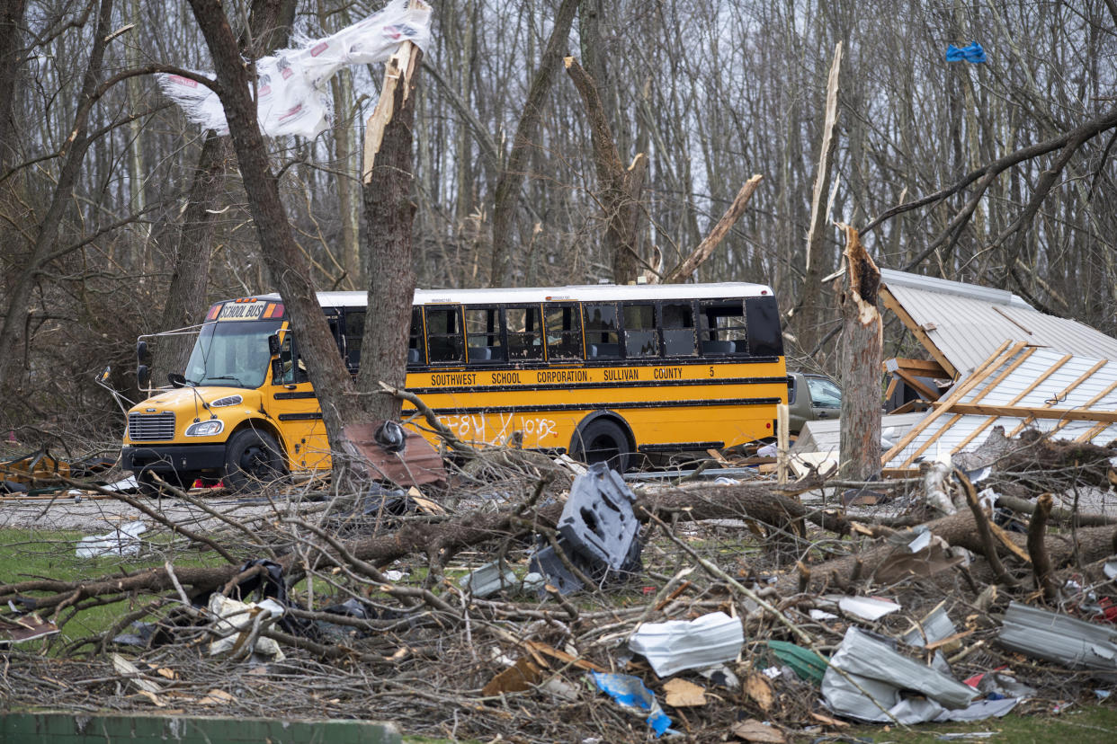 A school bus is surrounded by debris in an area that was heavily damage by a tornado in Sullivan, Ind., Saturday, April 1, 2023. Storms that spawned possibly dozens of tornadoes have killed several people in the South and Midwest. (AP Photo/Doug McSchooler)