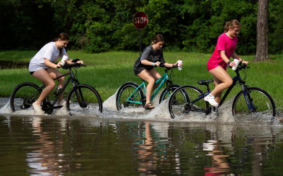 Biking through flood water near the bridge over Lake Houston along West Lake Houston Parkway