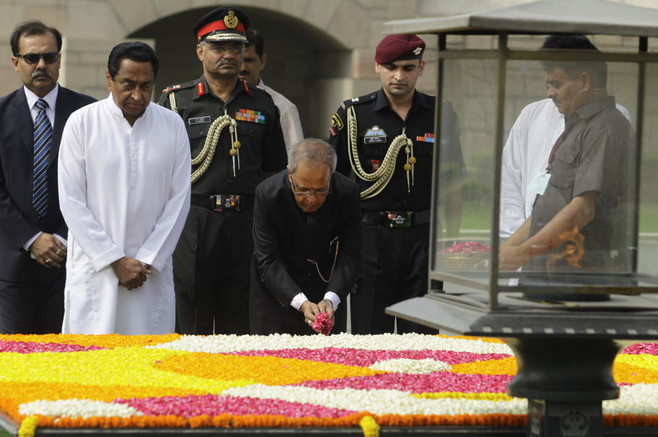 Political veteran Pranab Mukherjee offers flower petals at Rajghat, the memorial to the late Mahatma Gandhi, in New Delhi, India, Wednesday, July 25, 2012. Mukherjee was sworn in Wednesday as India's 13th president in an elaborate and symbolic ceremony in Parliament. (AP Photo/Altaf Qadri)