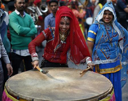 A performer plays a drum outside the headquarters of India's main opposition Bharatiya Janata Party (BJP) during the celebrations in New Delhi December 8, 2013. REUTERS/Ahmad Masood