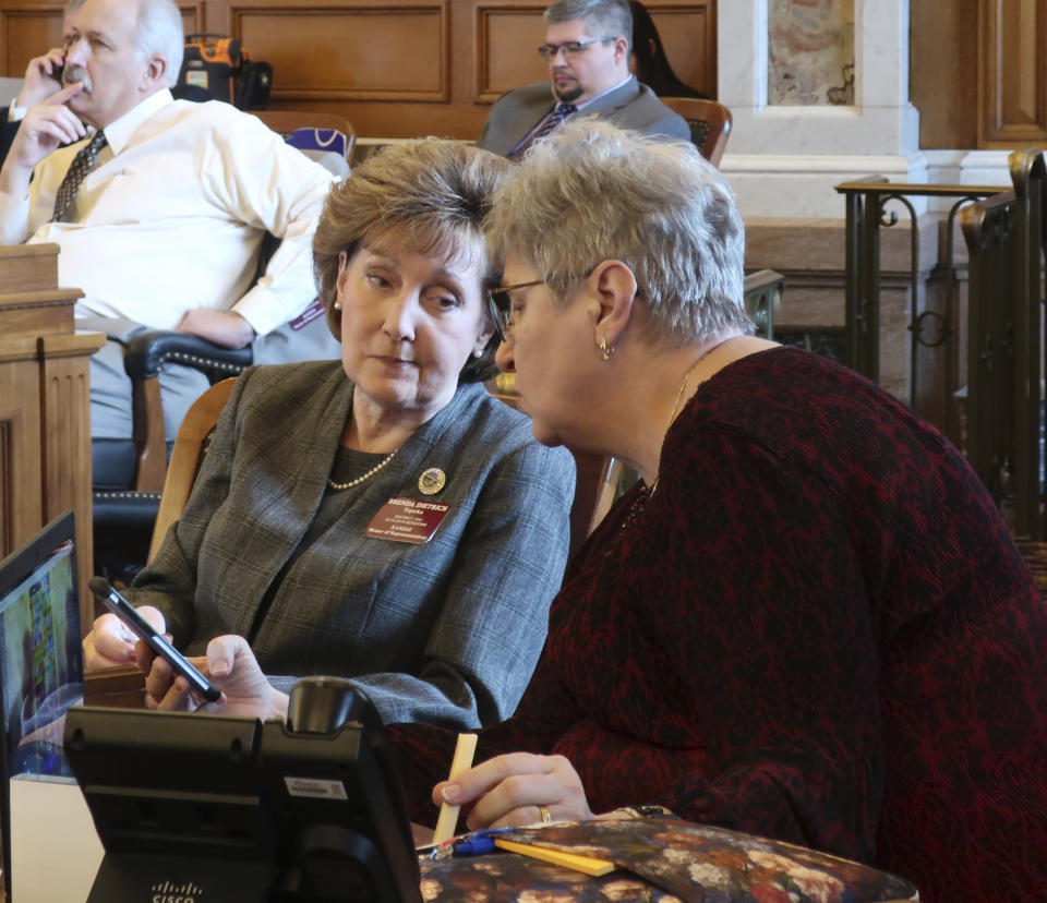 Kansas state Reps. Brenda Dietrich, left, R-Topeka, and Brenda Landwehr, right, R-Wichita, confer during a House debate, Tuesday, March 12, 2019, at the Statehouse in Topeka. Dietrich is a former local school superintendent who says she prefers a "clean and simple" school funding bill. (AP Photo/John Hanna)