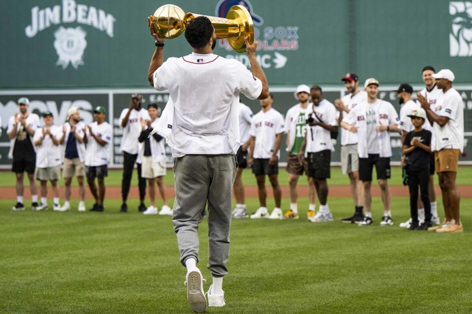 BOSTON, MA - JUNE 24: Jayson Tatum #0 of the Boston Celtics holds the Larry O'Brien Championship trophy as it is presented during a pre-game ceremony recognizing the NBA Finals Championship before a game between the Boston Red Sox and Toronto Blue Jays on June 24, 2024 at Fenway Park in Boston, Massachusetts.  (Photo by Billie Weiss/Boston Red Sox/Getty Images)