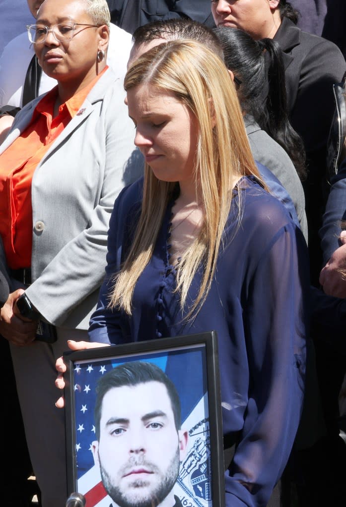 Stephanie Diller holding a photo of her late husband at a press conference. Brigitte Stelzer