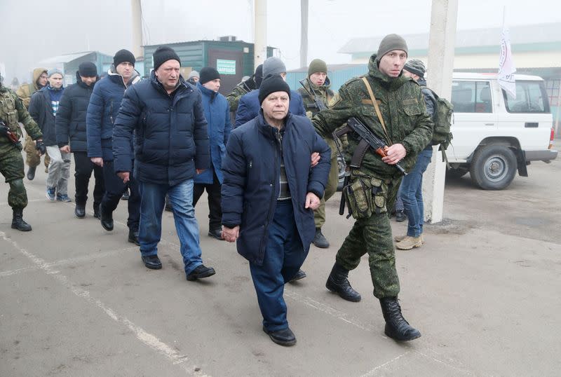 Men are escorted during prisoner of war exchange in Donetsk region