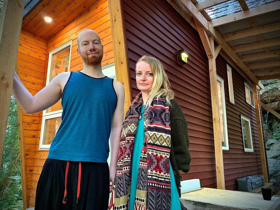 Bryce Knudtson and Saige Lancaster on the porch of their tiny home in Metchosin, B.C., say they haven't been able to find any other affordable rental spaces for their mobile property. (Adam van der Zwan/CBC - image credit)