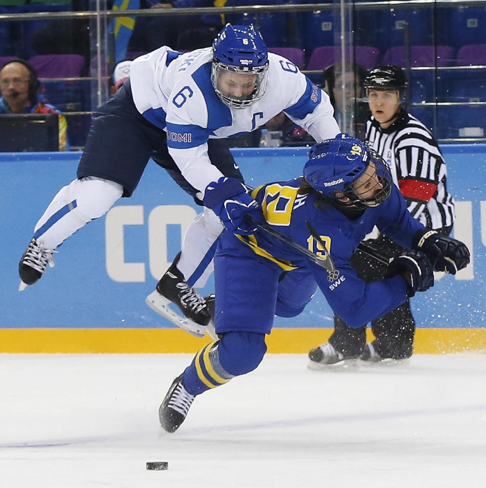 Jenni Hiirikoski of Finland (6) and Maria Lindh of Sweden collide during the 2014 Winter Olympics women's quarterfinal ice hockey game at Shayba Arena, Saturday, Feb. 15, 2014, in Sochi, Russia. (AP Photo/Petr David Josek)