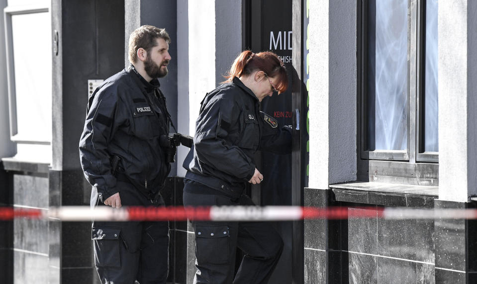 Two police officers enter a hookah bar in Hanau, Germany, Friday, Feb. 21, 2020 two days after a 43-year-old German man shot and killed several people at several locations in a Frankfurt suburb on Wednesday, Feb. 19, 2020. (AP Photo/Martin Meissner)