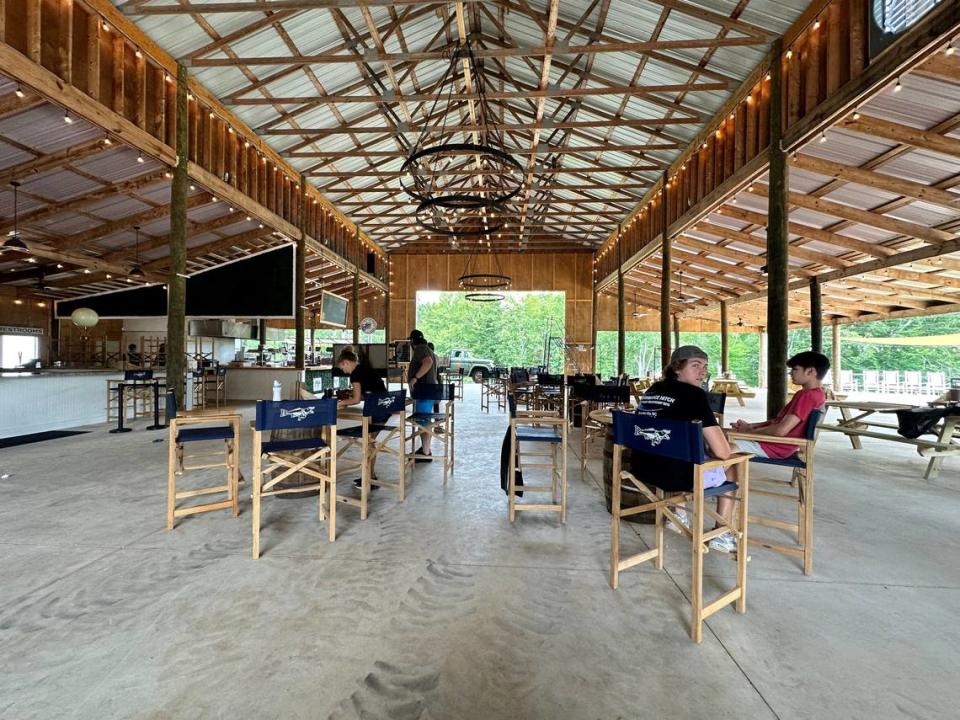 Shown is the interior of the massive barn at Bohemian Cattle Co. in Sherrills Ford, NC., that features a barbecue-focused restaurant, an entertainment stage, taproom, merch area and, on an outdoor patio, dozens of rockers.