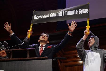 Masanori Niimi (L), of Japan, is joined by colleague Xiangyuan Jin (R), dressed as a mouse, as they accept the 2013 Medicine Prize during the 23rd First Annual Ig Nobel Prize ceremony at Harvard University in Cambridge, Massachusetts September 12, 2013. REUTERS/Brian Snyder