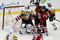 New Jersey Devils and Pittsburgh Penguins players watch as a goal by Pittsburgh Penguins right wing Bryan Rust goes past New Jersey Devils goaltender Mackenzie Blackwood (29) during the second period of an NHL hockey game, Sunday, April 11, 2021, in Newark, N.J. (AP Photo/Kathy Willens)