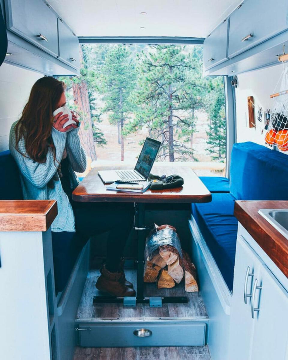 La instructora de yoga y viajera Sydney Ferbrache, de @divineontheroad, tiene en su autocaravana este amplio escritorio donde sentarse con la espalda recta y espacio incluso para estirar. La mesa se dobla para convertirse en cama. (Foto: Instagram / <a href="http://www.instagram.com/divineontheroad/" rel="nofollow noopener" target="_blank" data-ylk="slk:@divineontheroad;elm:context_link;itc:0;sec:content-canvas" class="link ">@divineontheroad</a>).