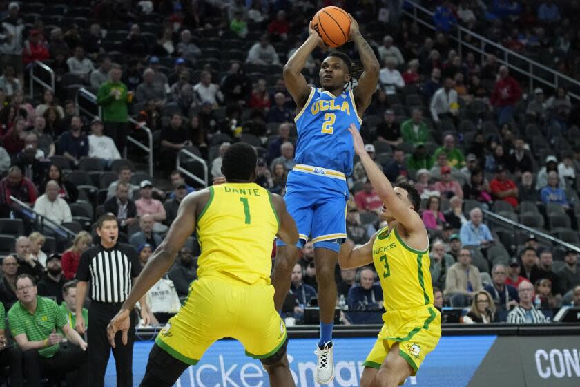 UCLA guard Dylan Andrews (2) shoots over Oregon center N'Faly Dante (1) and guard Jackson Shelstad.