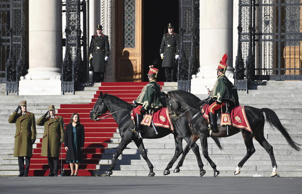 Hungarian President Katalin Novak, on carpet right, attends a flag-raising ceremony at the parliament building in Budapest, Hungary, Sunday, Oct. 23, 2022 to mark the 66th anniversary of the outbreak of the Hungarian revolution and war of independence against communist rule and the Soviet Union in 1956. (Noemi Bruzak/MTI via AP)