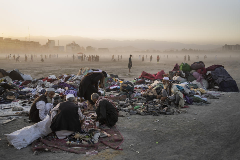 Afghans sort second-hand clothes at the Chaman-e-Hozari Park in Kabul, Afghanistan, Friday, Sept. 17, 2021. (AP Photo/Bernat Armangue)