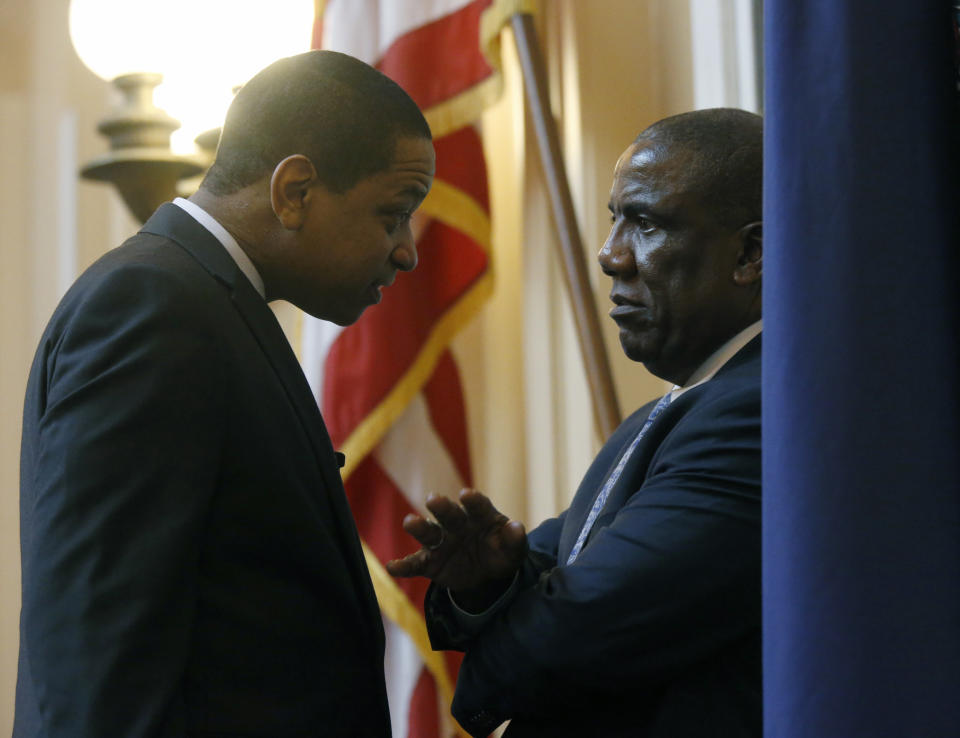 Lt. Gov. Justin Fairfax, left, Sen. Lionell Spruill, D-Chesapeake, , right, confer before the floor session of the Virginia Senate at the State Capitol in Richmond, Va., Wednesday, Feb. 6, 2019. (Bob Brown/Richmond Times-Dispatch via AP)