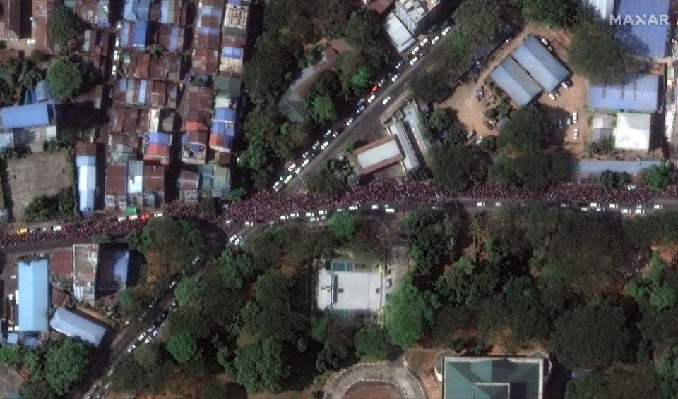 In this handout satellite photo provided by Maxar, large crowds take part in protests following last week's military coup, in Yangon, Myanmar, Monday, Feb. 8, 2021. Myanmar’s military government has imposed a curfew and bans on gatherings of more than five people in the country’s two biggest cities as protests against its coup show no sign of abating. (Maxar via AP)