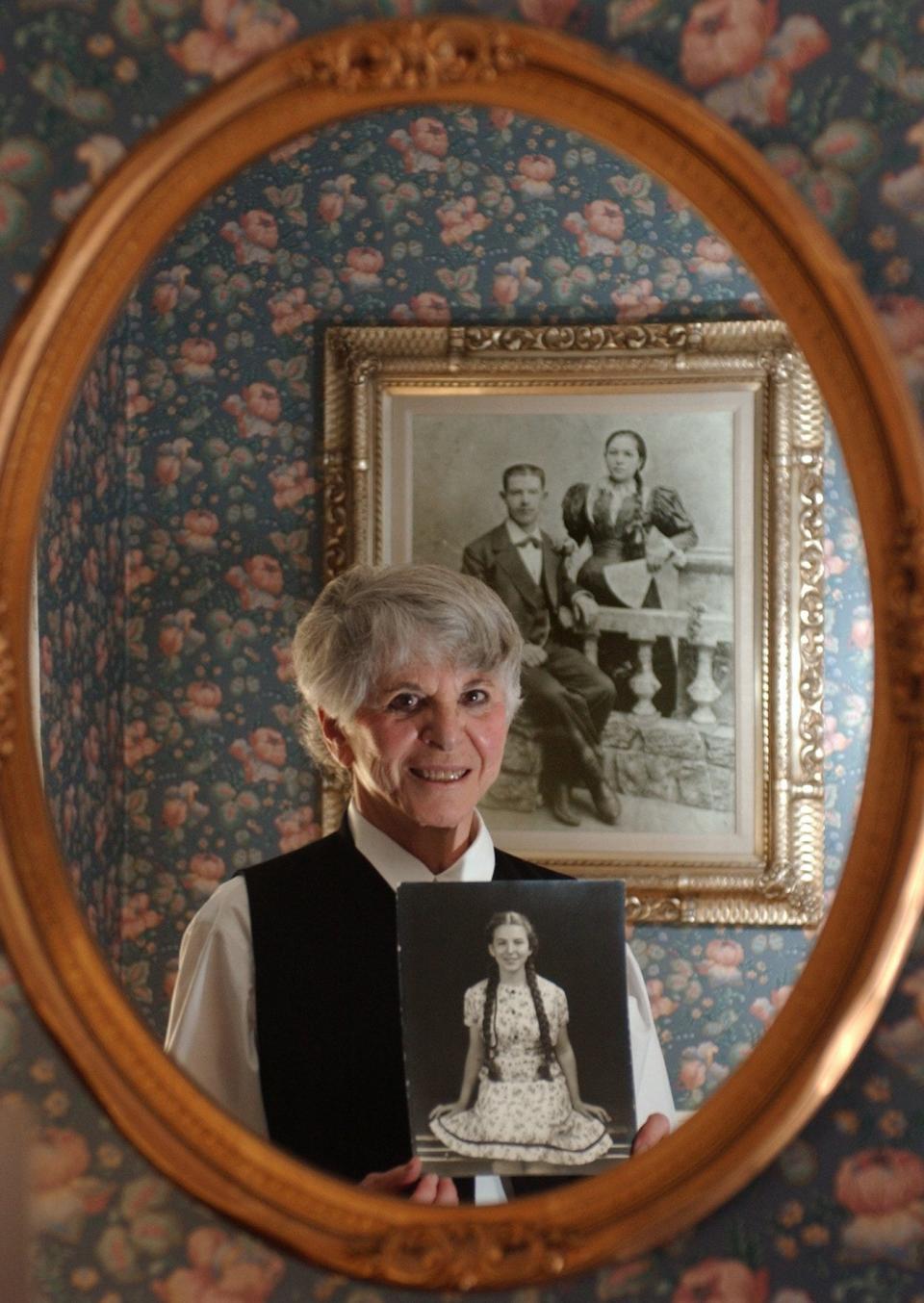 In 2002, Mildred Neiman Korach of Akron holds a photo of herself at 10 years old with long braids. In the photo on the wall behind her is a photo of her mother, Anna, taken in Minsk in the early 1900s.