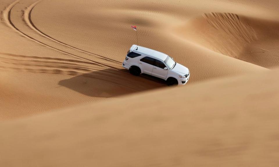 A man drives his car at the desert near Sharjah, United Arab Emirates, 25 June, 2021.