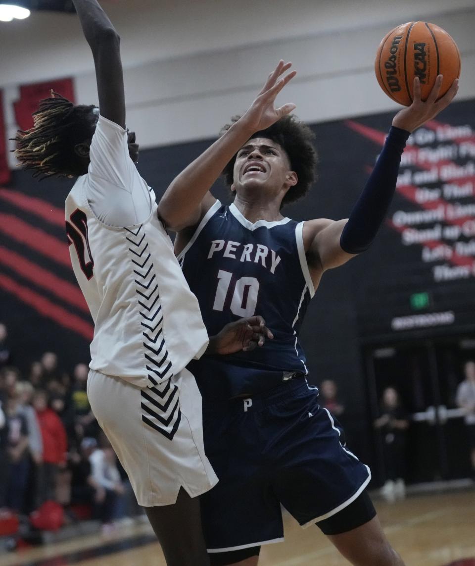 Nov 29, 2022; Peoria, Ariz, U.S.;  Perry guard/wing Koa Peat (10) lays the ball up against Liberty forward/center Ring Nyeri (20) at Liberty High School gym. Mandatory Credit: Michael Chow-Arizona Republic