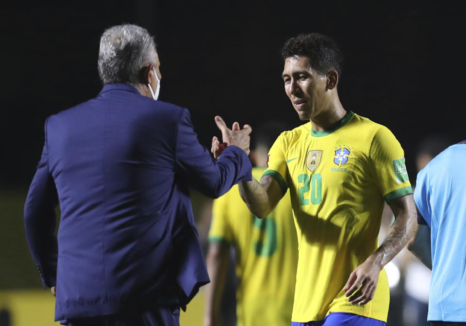 Brazil's coach Tite, left, and Brazil's Roberto Firmino celebrate at the end of a qualifying soccer match against Venezuela for the FIFA World Cup Qatar 2022 in Sao Paulo, Brazil, Friday, Nov.13, 2020. Brazil won 1-0. (Fernando Bizerra/Pool via AP)